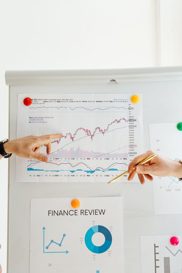 Mastering the First Impression: Your intriguing post title goes here Hands pointing to financial charts during an office presentation.